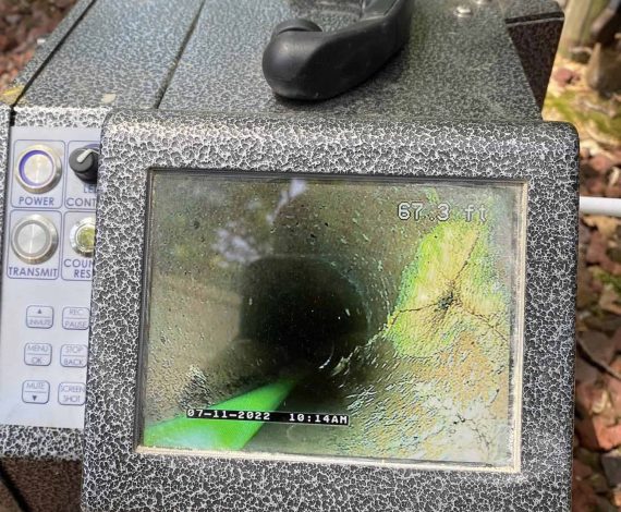 The image shows a Prodigy Sewer and Drain camera checking the inside of pipes, highlighting the need for cleaning or repairs.